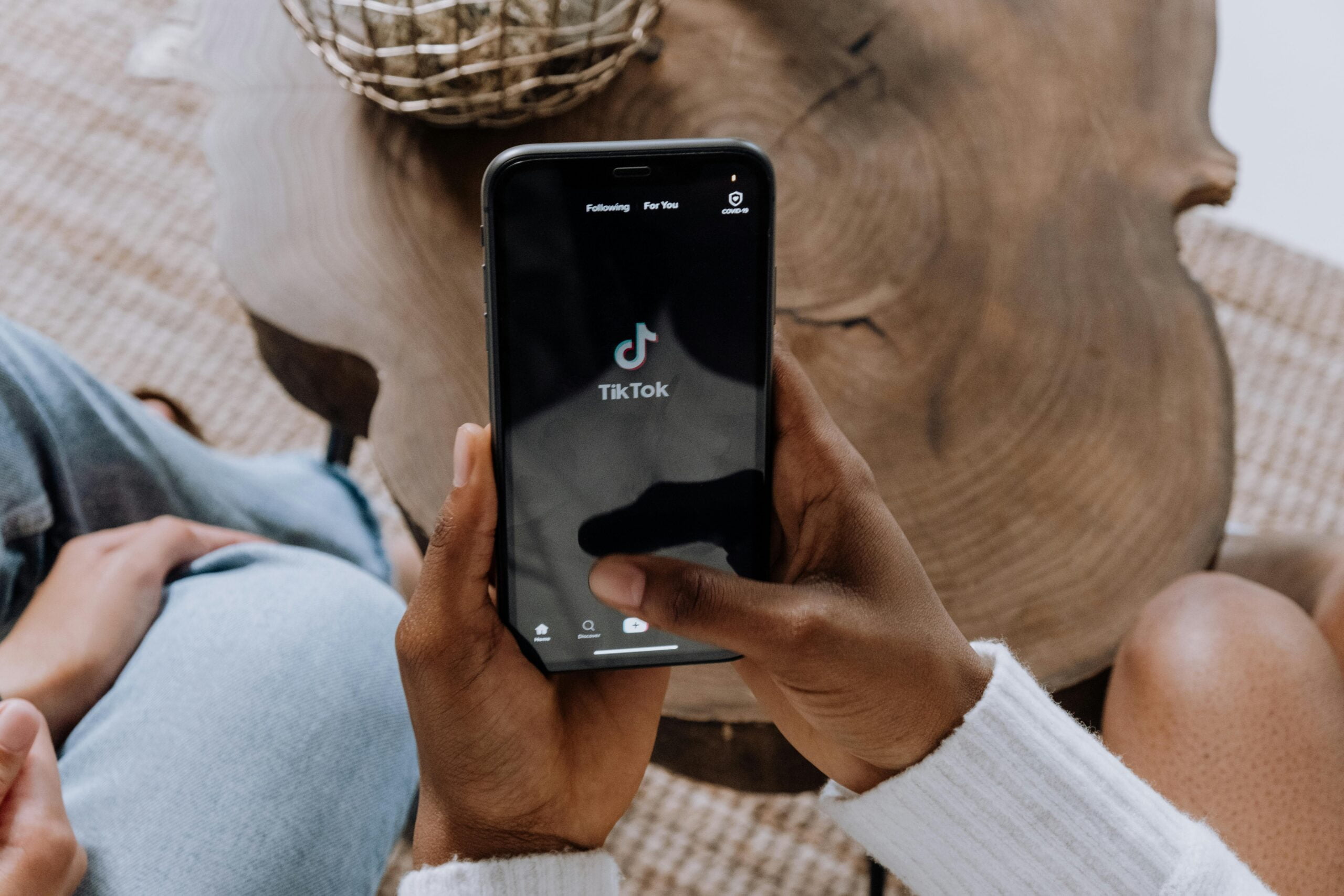 A person holding a phone creating content on TikTok