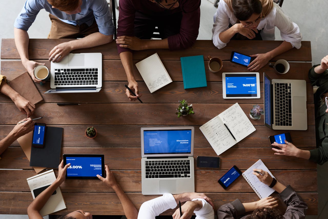 A group of IT consultants sitting around a table with laptops and tablets